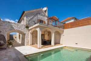 a villa with a swimming pool and a house at Rustic Villa Kameni dvori heated pool in Sveti Filip i Jakov