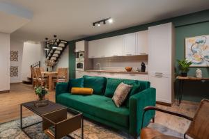 a living room with a green couch and a kitchen at Rustic Villa Kameni dvori heated pool in Sveti Filip i Jakov