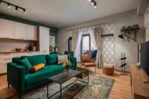 a living room with a green couch and a table at Rustic Villa Kameni dvori heated pool in Sveti Filip i Jakov