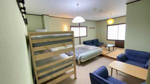 a bedroom with a bed and blue chairs in a room at Nona Madarao in Madarao Kogen