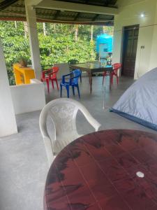 a patio with chairs and a table and a table and chairs at Skyview Homestay Devaramane Mudigere in Mudigere
