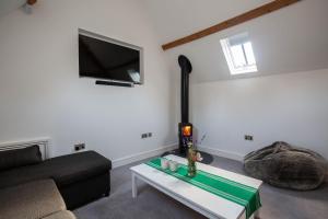 a living room with a couch and a table at The Stables in Mollington