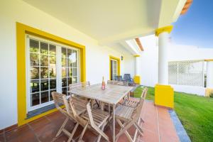 ein Holztisch und Stühle auf einer Terrasse in der Unterkunft Burgo D Sancho I 17 in Amoreira