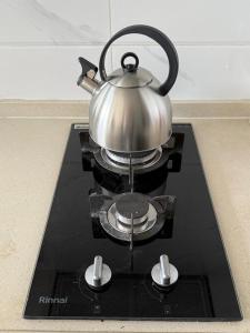 a tea kettle sitting on top of a stove at Skyhouse BSD Apartment studio 2 in Kedeper