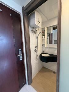 a bathroom with a shower and a sink in it at Skyhouse BSD Apartment studio 2 in Kedeper