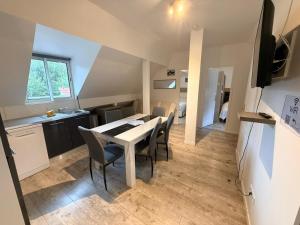 a kitchen and dining room with a table and chairs at Résidence des Fleurs in Cabourg