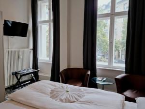 a hotel room with a bed and a window at Hotel Gasteiner Hof in Berlin