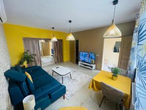 a living room with a blue couch and a tv at Luxury Apartments in Wrocław +1 photo