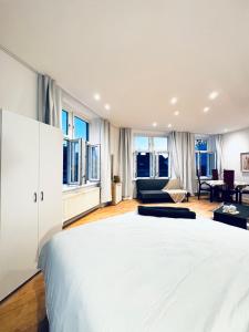 a bedroom with a large white bed and a living room at Lovely 4BR shared Apartment Near Kaufpark Alterlaa in Vienna +45 photos