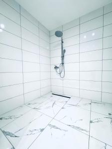 a white bathroom with a shower in a wall at Lovely 4BR shared Apartment Near Kaufpark Alterlaa in Vienna