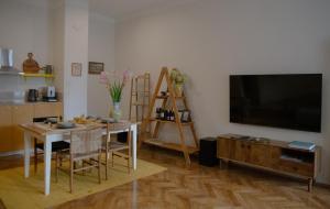 a living room with a table and a flat screen tv at Dzeltenais Dāvids in Liepāja