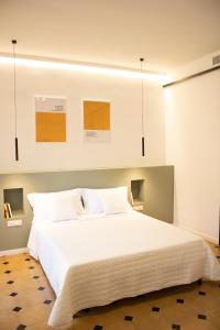 a bedroom with a large bed with white sheets at A-Poggio in Poggiomarino