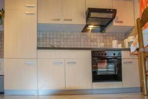 a kitchen with white cabinets and a black oven at Nina NINA in Sögel