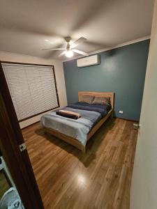 a bedroom with a bed and a ceiling fan at Home Near Melbourne Airport in Meadow Heights