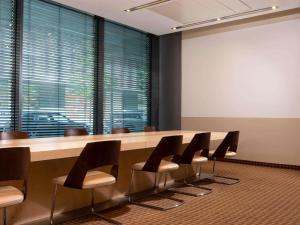 una sala conferenze con un lungo tavolo e sedie di Mövenpick Hotel Frankfurt City Messe a Francoforte sul Meno