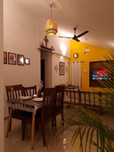 a dining room and living room with a table and chairs at Cozy Cabana - Maynard Palace in Benaulim