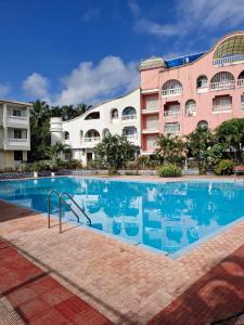 a swimming pool in front of a building at Cozy Cabana - Maynard Palace in Benaulim