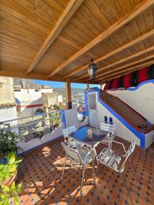 a patio with a table and chairs on a balcony at Dar Lalla chafia 2 studio triplex in Chefchaouene +9 photos