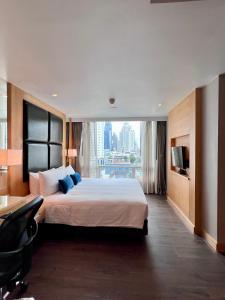 a bedroom with a large bed and a large window at Sora Resort & Suites Sukhumvit in Bangkok