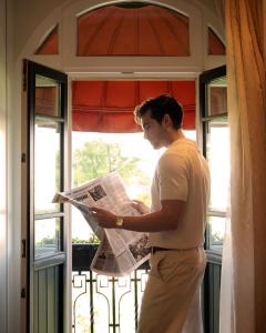 a man reading a newspaper in front of a window at Park Hyatt Istanbul - Macka Palas in Istanbul +138 photos