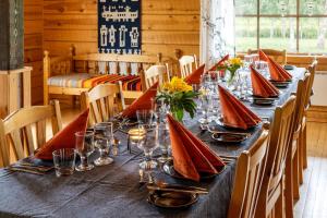 a long table with red napkins and glasses on it at Isokenkäisten Klubi - Wilderness Lodge in Kiviperä