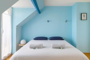 a bedroom with a large white bed with blue walls at GuestReady - Fabulous House in Clamart in Clamart