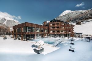 a building with a pool in the snow at AlpenParks THE SECRET Sölden in Sölden