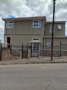 a house with a fence in front of it at Faranie Guesthouse in Oudtshoorn