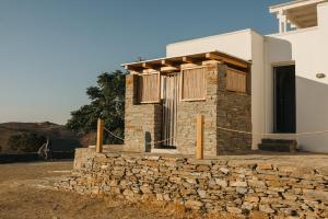 a house with a stone wall next to a building at Kea Villa Thea by A&D Properties in Otziás