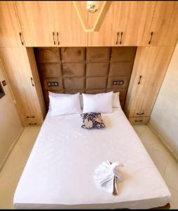 a bed in a small room with white sheets at les appartements vip madinat bades alhoceima in Al Hoceïma