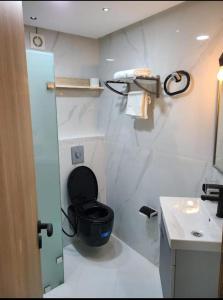 a bathroom with a black toilet and a sink at les appartements vip madinat bades alhoceima in Al Hoceïma +24 photos
