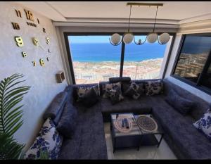 a living room with a couch and a large window at les appartements vip madinat bades alhoceima in Al Hoceïma