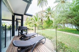 a screened in porch with two chairs and a grill at Beachside on Pacific in Mission Beach