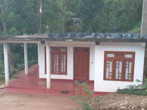 a small house with red doors and a roof at Freedom Lodge in Ella