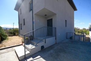 Casa blanca con balcón y escalera en Casa B, en Basardilla