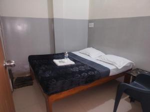 a small bed in a room with a bottle on it at ss comfort in Mysore