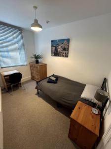 ein Schlafzimmer mit einem Bett, einem Schreibtisch und einem Tisch in der Unterkunft Entire house in central Bournemouth, sleeps 8, 13 min walk to beach in Bournemouth