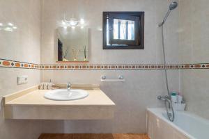 a bathroom with a sink and a tub and a mirror at Aretina's Lanzarote Retreat in Costa Teguise +29 photos