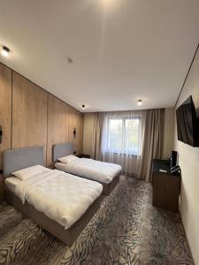ein Hotelzimmer mit zwei Betten und einem Fernseher in der Unterkunft MILANIUM hotel in Almaty + 55 Fotos