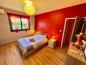 a bedroom with red walls and a bed in a room at " Sweet Home " Jardin - 4 ch - Wifi - Thalès in Cugnaux