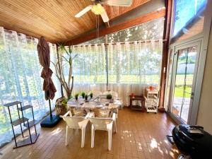 una sala da pranzo con tavolo, sedie e ampie finestre di " Sweet Home " Jardin - 4 ch - Wifi - Thalès a Cugnaux