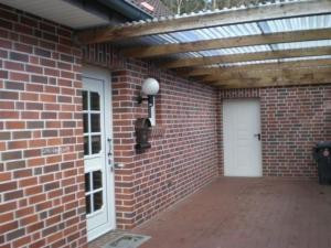 a brick building with awning and a white door at Sögel HA01 in Sögel