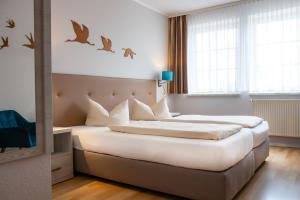 Un dormitorio con una cama grande con pájaros en la pared. en Hotel ELBRIVERA Alt Prester, en Magdeburgo 41 fotos más