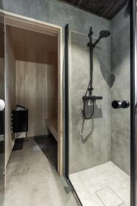 une douche dans une salle de bain avec une porte vitrée dans l'établissement Nyørk Chalet, Hemsedal, à Hemsedal