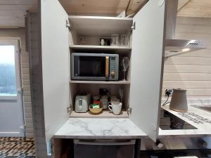 ナントウィッチにある1 Bed Cosy Open Plan Apartmentの白いキャビネット(電子レンジ付)が備わるキッチン +9枚の写真