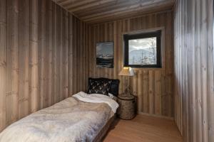 une chambre avec un lit dans une pièce en bois dans l'établissement Nyørk Chalet, Hemsedal, à Hemsedal