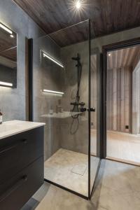 une salle de bain avec une douche avec une porte vitrée dans l'établissement Nyørk Chalet, Hemsedal, à Hemsedal