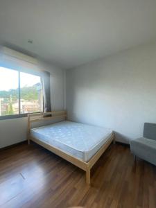 a bedroom with a bed and a couch and a window at Town House in Ban Ket Ho
