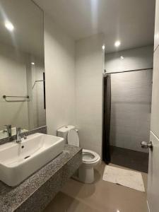 a white bathroom with a sink and a toilet at Town House in Ban Ket Ho