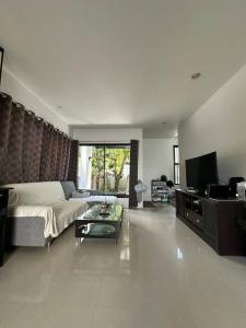 a living room with a couch and a tv at Town House in Ban Ket Ho